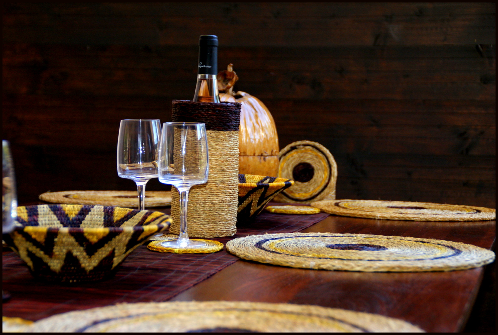 table décorée avec des sets ronds, panière, verres et porte-bouteille